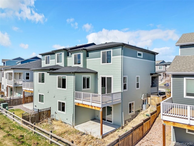 rear view of house with a patio, a residential view, and a fenced backyard