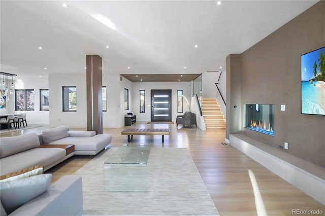 living area with recessed lighting, stairway, and light wood finished floors
