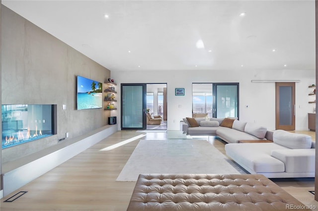 living room with light wood finished floors and recessed lighting