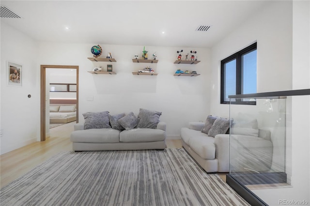 living area with recessed lighting, wood finished floors, and visible vents