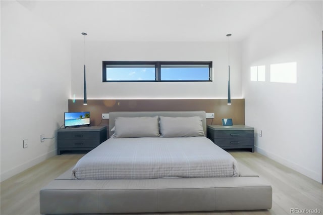 bedroom with light wood finished floors and baseboards