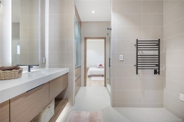full bathroom featuring ensuite bath, radiator heating unit, vanity, and tile walls