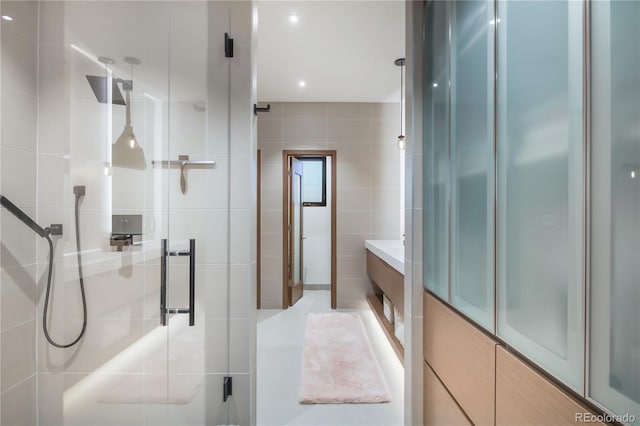 bathroom with tile walls and a shower stall