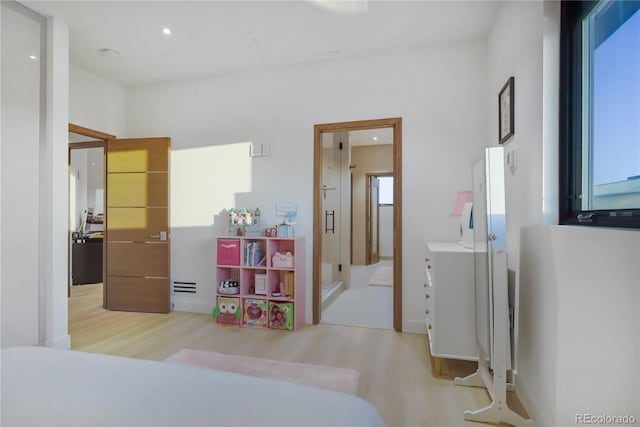 bedroom featuring recessed lighting, light wood-style floors, and multiple windows