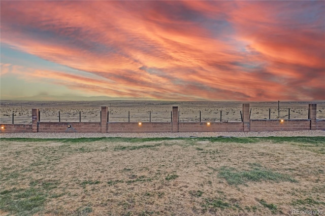yard at dusk featuring fence
