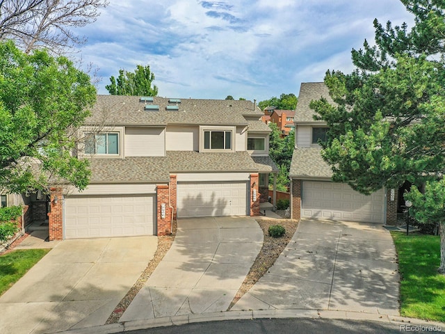12658 W 1st Pl Unit 78, Denver, CO 80228 - view of front of property featuring driveway, brick siding, an attached garage, and roof with shingles