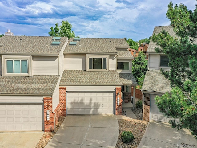 12658 W 1st Pl Unit 78, Denver, CO 80228 - view of property with brick siding, driveway, an attached garage, and a shingled roof