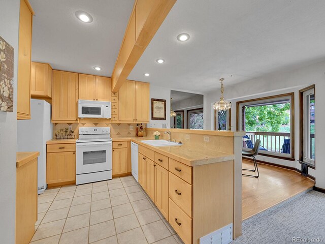 12658 W 1st Pl Unit 78, Denver, CO 80228 - kitchen featuring white appliances, light brown cabinetry, a peninsula, light countertops, and tasteful backsplash