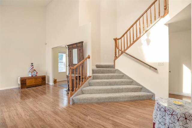 801 S 15th Ave, Brighton, CO 80601 - stairway with a high ceiling, wood finished floors, and baseboards