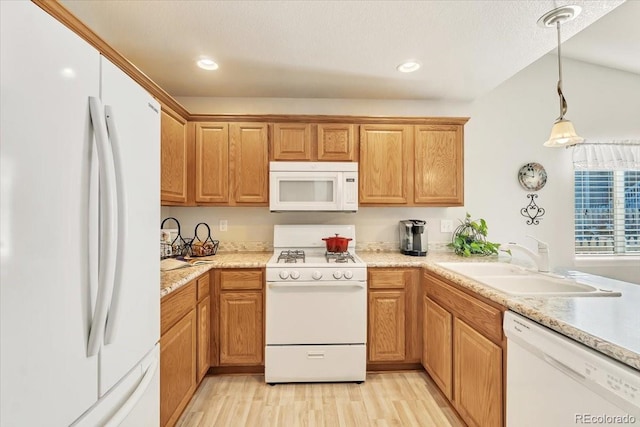 kitchen featuring sink, light hardwood / wood-style floors, pendant lighting, and white appliances