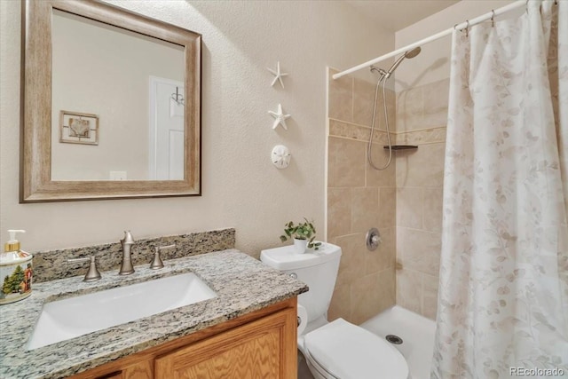 bathroom with toilet, vanity, and curtained shower