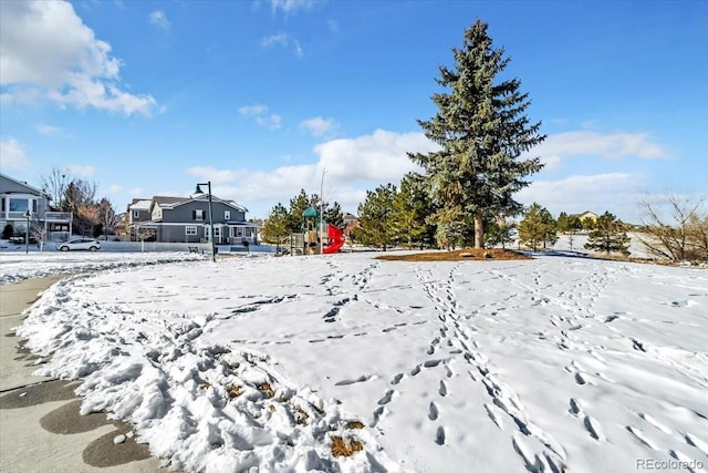 yard covered in snow featuring a playground