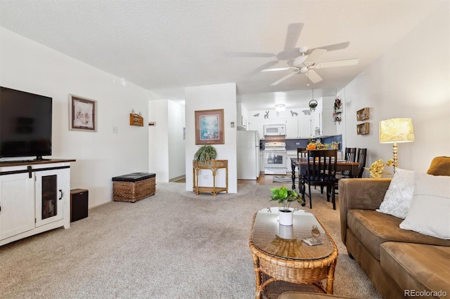 carpeted living room featuring ceiling fan and a textured ceiling