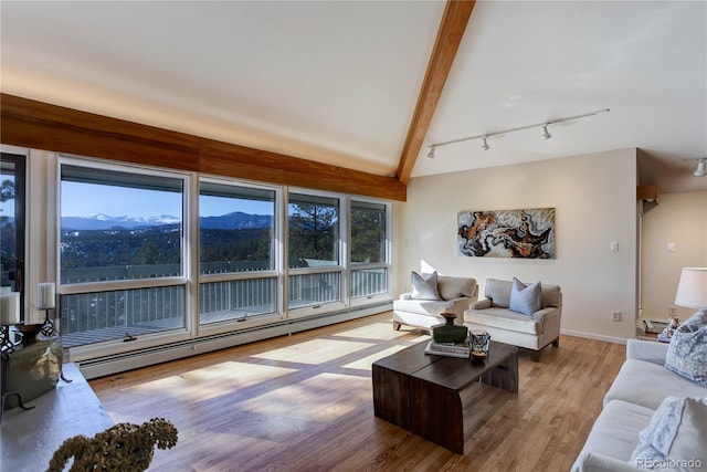 living room with a mountain view, lofted ceiling with beams, light hardwood / wood-style floors, and a baseboard heating unit