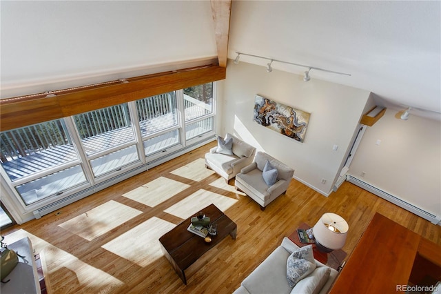 living room with light hardwood / wood-style flooring, rail lighting, beamed ceiling, and baseboard heating