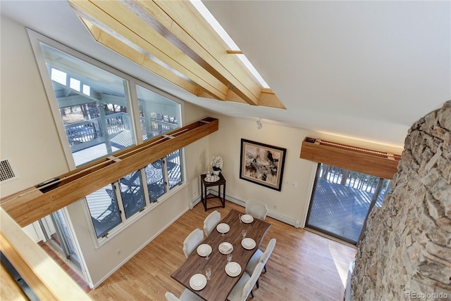 interior space featuring a skylight, a baseboard radiator, and light wood-type flooring