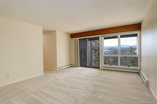 unfurnished room featuring a baseboard radiator, a mountain view, and light colored carpet