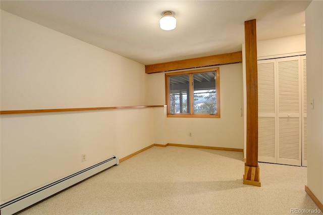 unfurnished bedroom with baseboard heating, carpet flooring, and a closet