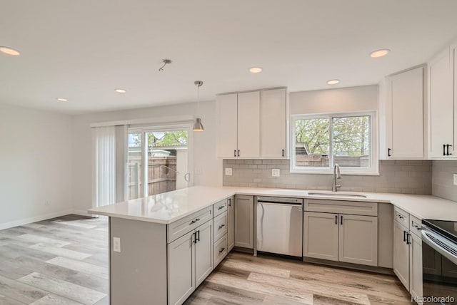 kitchen featuring kitchen peninsula, a healthy amount of sunlight, sink, and stainless steel appliances