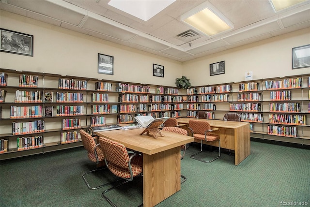 carpeted office with a paneled ceiling