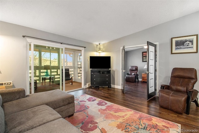 living room with a textured ceiling and dark hardwood / wood-style flooring