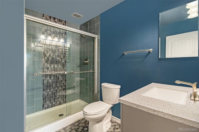 bathroom featuring tile patterned flooring, vanity, an enclosed shower, and toilet