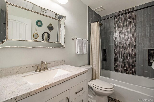 full bathroom with vanity, shower / bathtub combination with curtain, and toilet