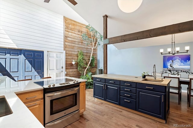 6305 W 6th Ave Unit C12, Lakewood, CO 80214 - kitchen with stainless steel electric range oven, high vaulted ceiling, light wood-type flooring, a chandelier, and hanging light fixtures