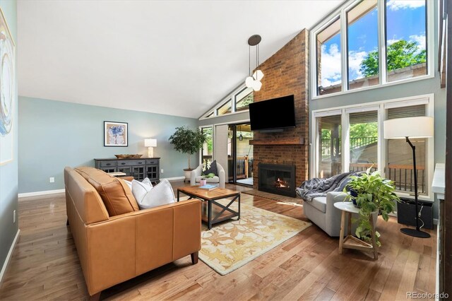 6305 W 6th Ave Unit C12, Lakewood, CO 80214 - living room with light wood finished floors, a brick fireplace, and high vaulted ceiling