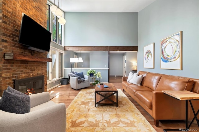 6305 W 6th Ave Unit C12, Lakewood, CO 80214 - living area featuring a towering ceiling, wood finished floors, and a brick fireplace