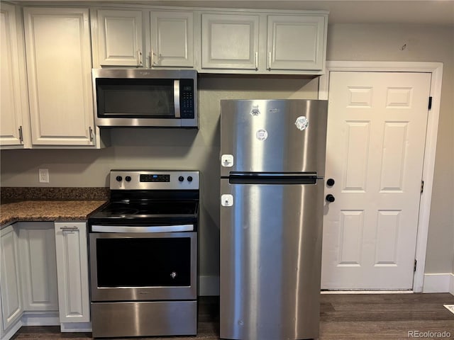 1222 Yosemite St, Denver, CO 80220 - kitchen with appliances with stainless steel finishes, dark countertops, and dark wood finished floors