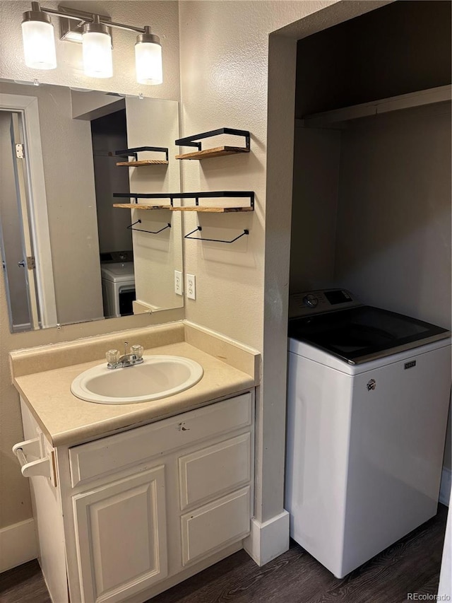 1222 Yosemite St, Denver, CO 80220 - bathroom with washer / clothes dryer, wood finished floors, and vanity