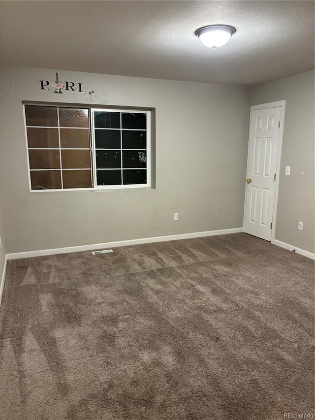 1222 Yosemite St, Denver, CO 80220 - carpeted empty room featuring baseboards and a textured ceiling