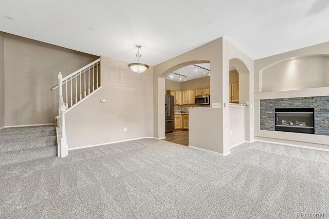 12711 Colorado Blvd Unit 714G, Thornton, CO 80241 - unfurnished living room with light colored carpet, stairs, baseboards, and a fireplace