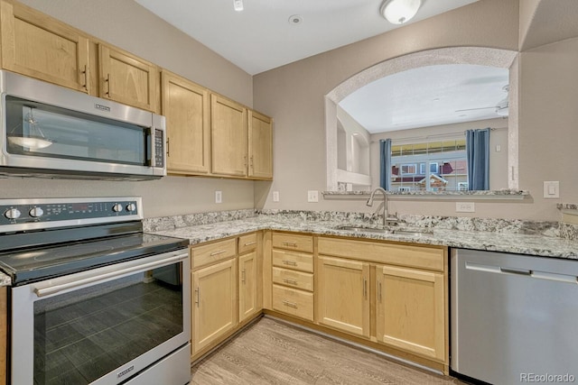 12711 Colorado Blvd Unit 714G, Thornton, CO 80241 - kitchen with stainless steel appliances, a sink, light brown cabinetry, light wood-type flooring, and light stone counters