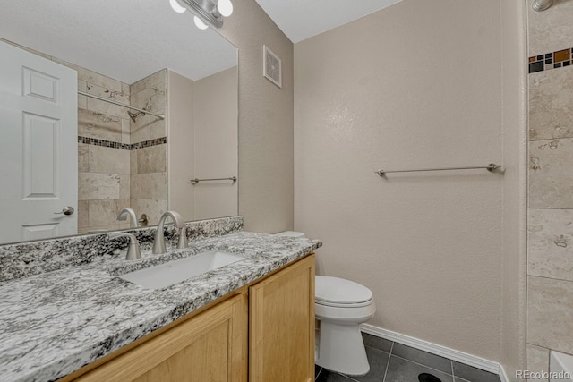12711 Colorado Blvd Unit 714G, Thornton, CO 80241 - bathroom featuring toilet, vanity, tile patterned floors, a tile shower, and baseboards