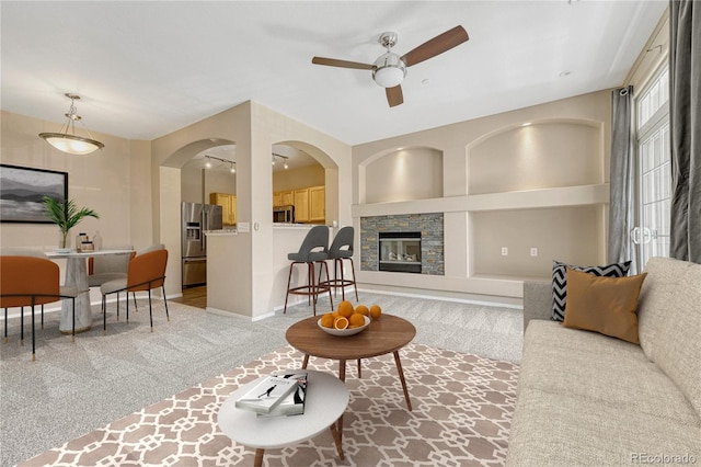 12711 Colorado Blvd Unit 714G, Thornton, CO 80241 - living room featuring a ceiling fan, carpet floors, a fireplace, and arched walkways