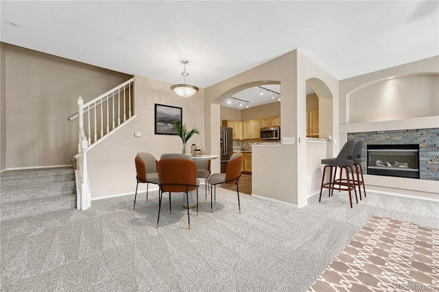 12711 Colorado Blvd Unit 714G, Thornton, CO 80241 - dining room featuring light carpet, stairway, a fireplace, and baseboards