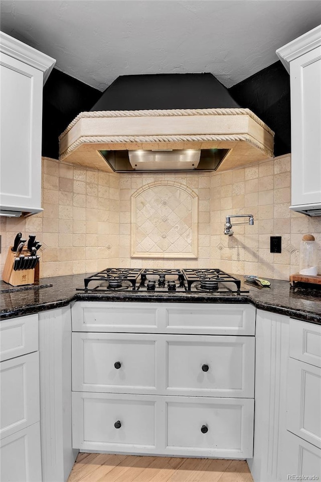 kitchen with white cabinets and dark stone countertops