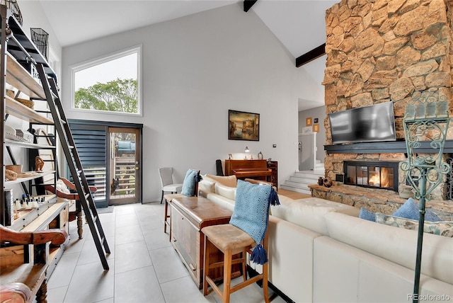 living area featuring a fireplace, beam ceiling, light tile patterned flooring, and high vaulted ceiling