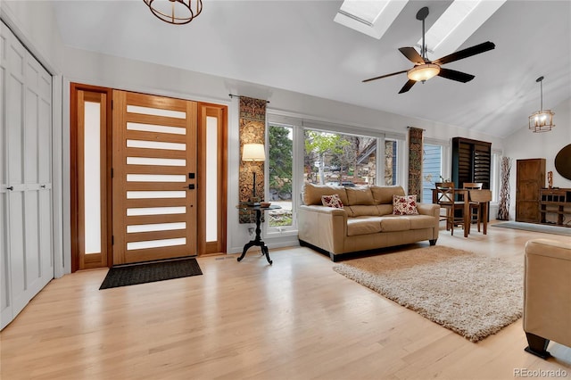 entrance foyer with ceiling fan, light wood-style flooring, and lofted ceiling with skylight