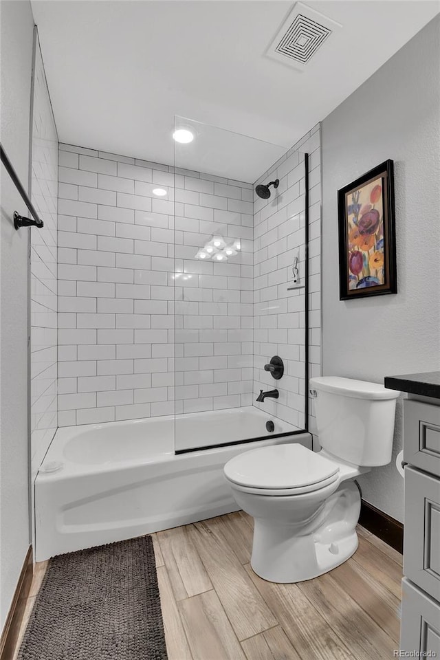 full bath featuring vanity, bathtub / shower combination, toilet, wood finished floors, and visible vents