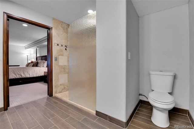 ensuite bathroom with wood tiled floor, walk in shower, ensuite bath, and toilet