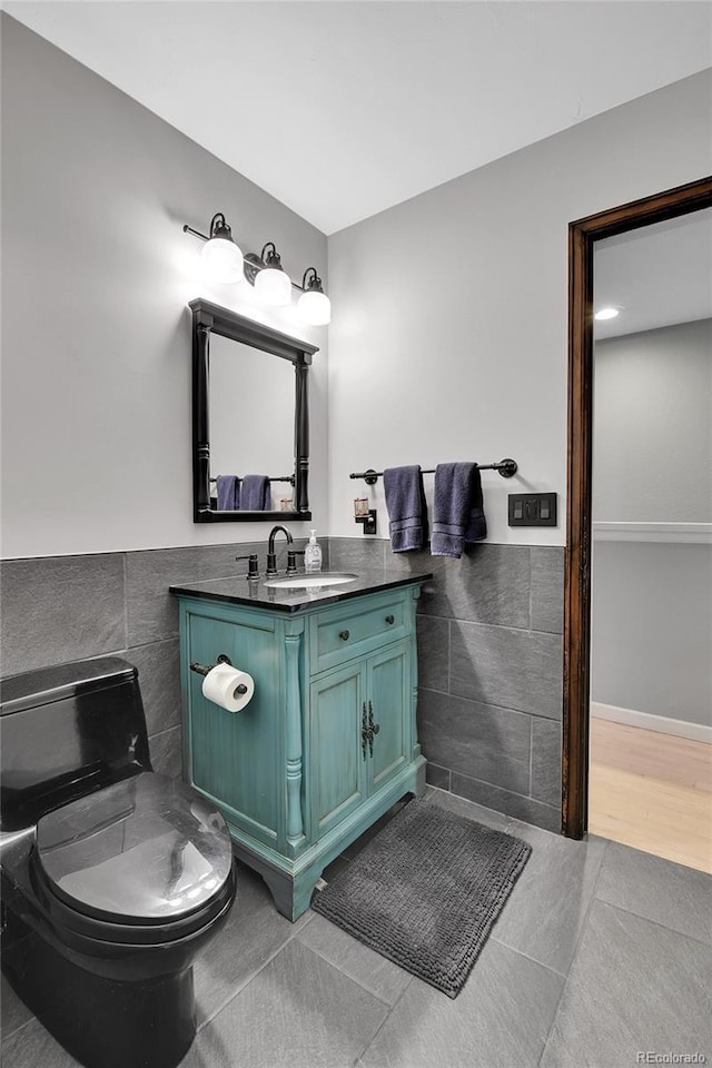 bathroom featuring wainscoting, tile walls, tile patterned flooring, and vanity