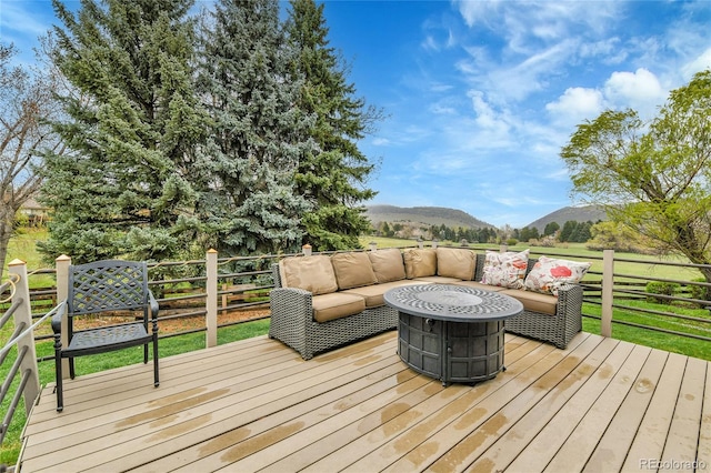deck featuring an outdoor living space with a fire pit and a mountain view