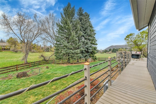 deck featuring a lawn, a mountain view, a rural view, and fence