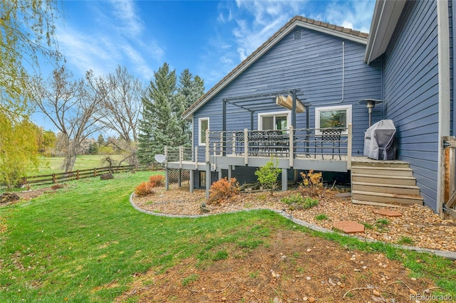 back of house with a lawn, fence, and a deck