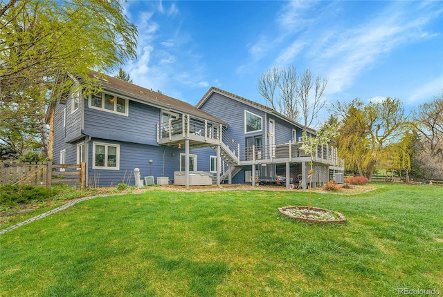 back of house with a lawn, a jacuzzi, fence, and a deck