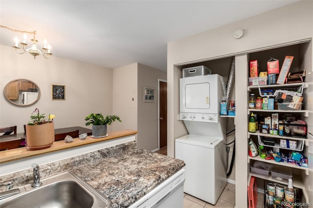 4636 S Dillon Ct Unit B, Aurora, CO 80015 - laundry room featuring stacked washing machine and dryer, light tile patterned floors, and a chandelier