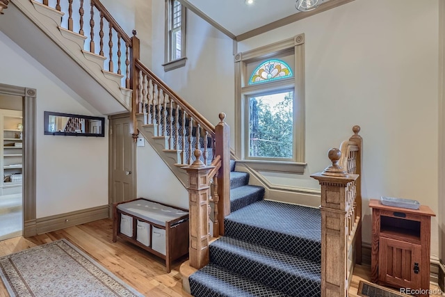 stairway with wood finished floors and baseboards